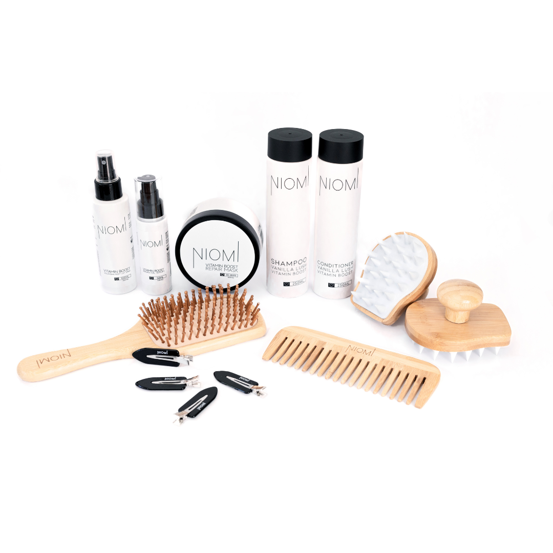 Hair care product set with bottles, brushes, and a comb on a white background