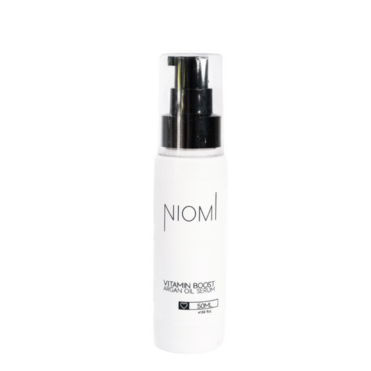 A pump bottle of NIOMI Vitamin Boost Argan Oil Serum, white in color with brand and product name printed on the front.