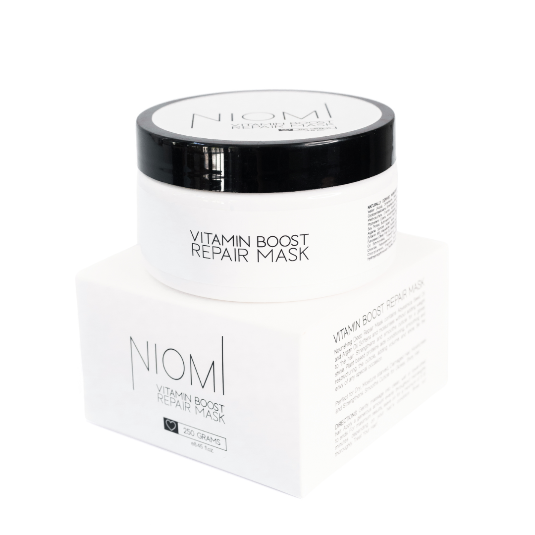 NIOMI Vitamin Boost Repair Mask packaging with product visible inside. The packaging is white with black and silver text and design elements.