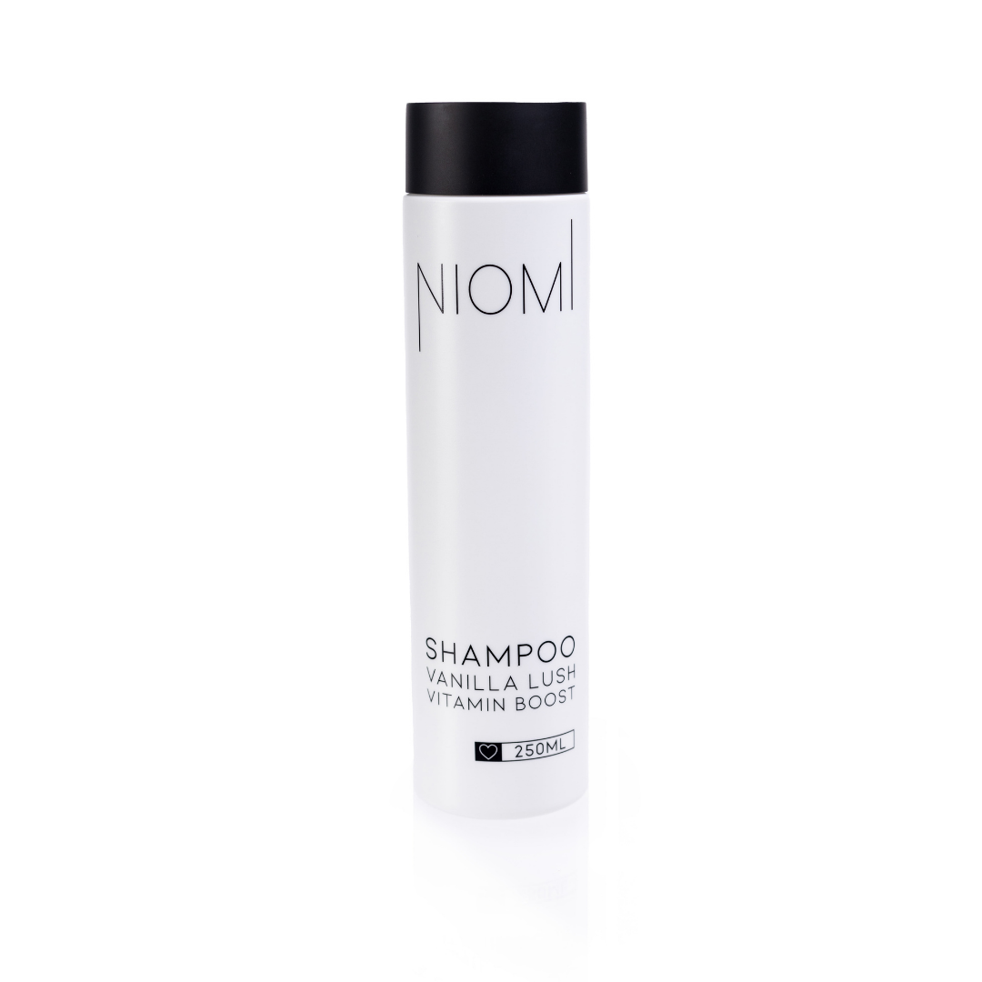 A bottle of NIOMI Vanilla Lush, Vitamin Boost Shampoo 250ml with a white label and black cap.