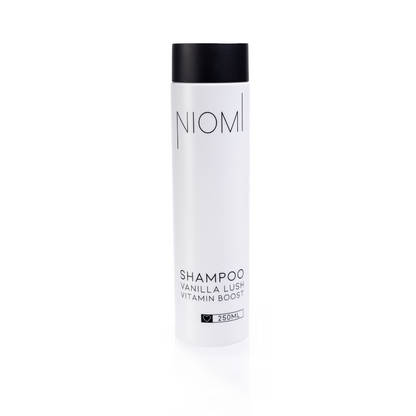 A bottle of NIOMI Vanilla Lush, Vitamin Boost Shampoo 250ml with a white label and black cap.